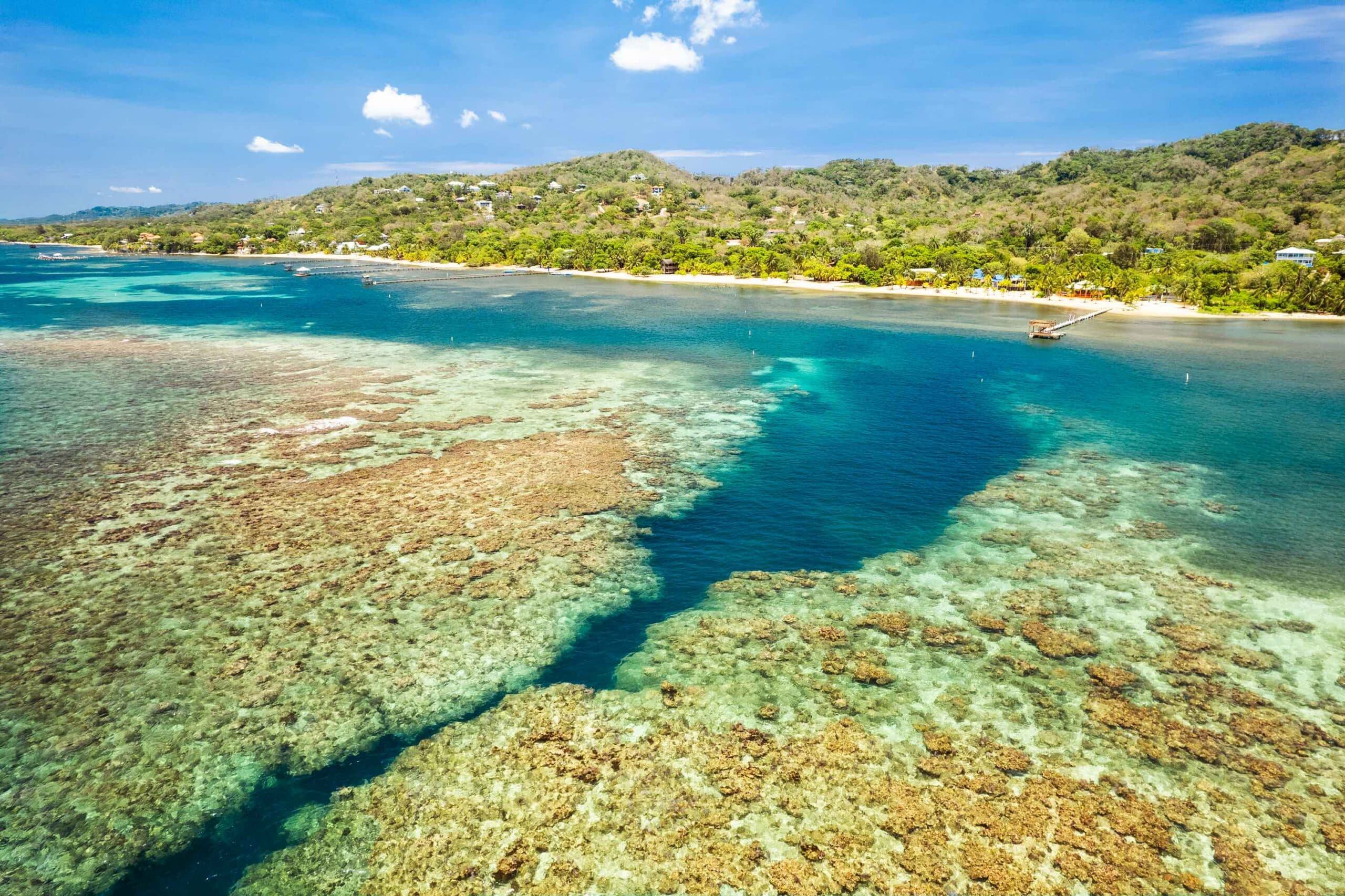 Aerial panorama of the Spooky Channel reef and the Sandy Bay coastline in Roatan, Honduras.
